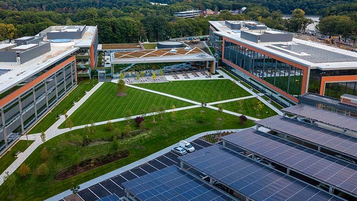 Aerial view of three buildings, one with solar panels on the roof