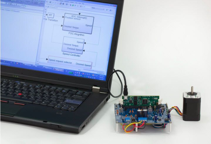 A laptop connected to a small circuit board that is connected to an electric motor.